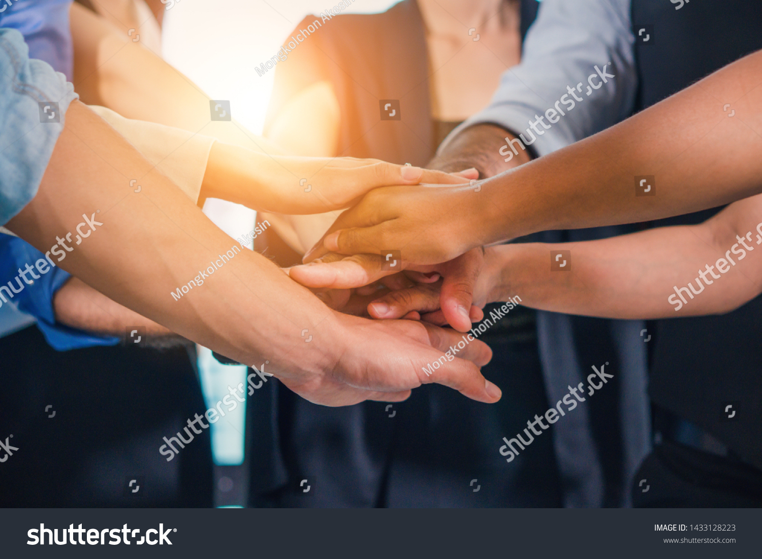 business hands stacking together in teamwork gesture