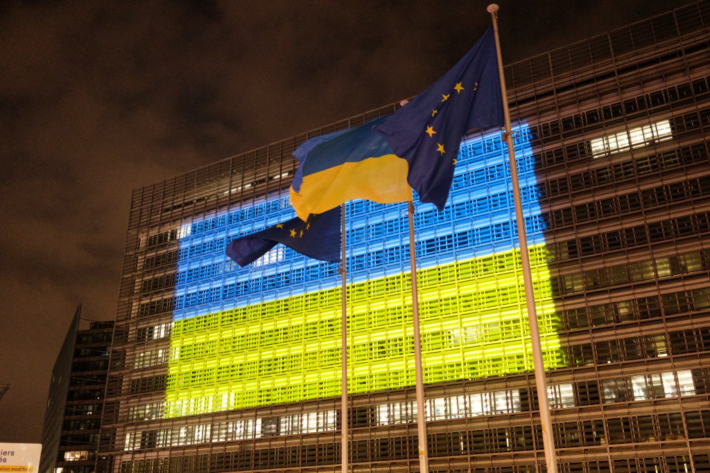 European Commission building lit up in Ukraine flag colors blue and yellow at night