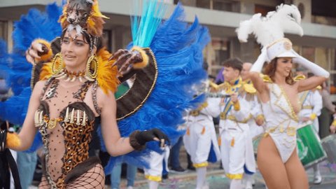 Slow motion cinematic shot of carnival dancers on the coast