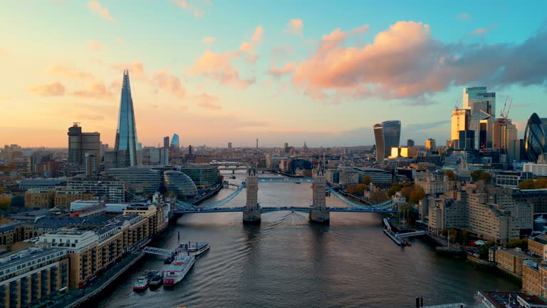 Cinematic shot of London skyline at sunset featuring Tower Bridge and The Shard, high resolution, golden hour lighting