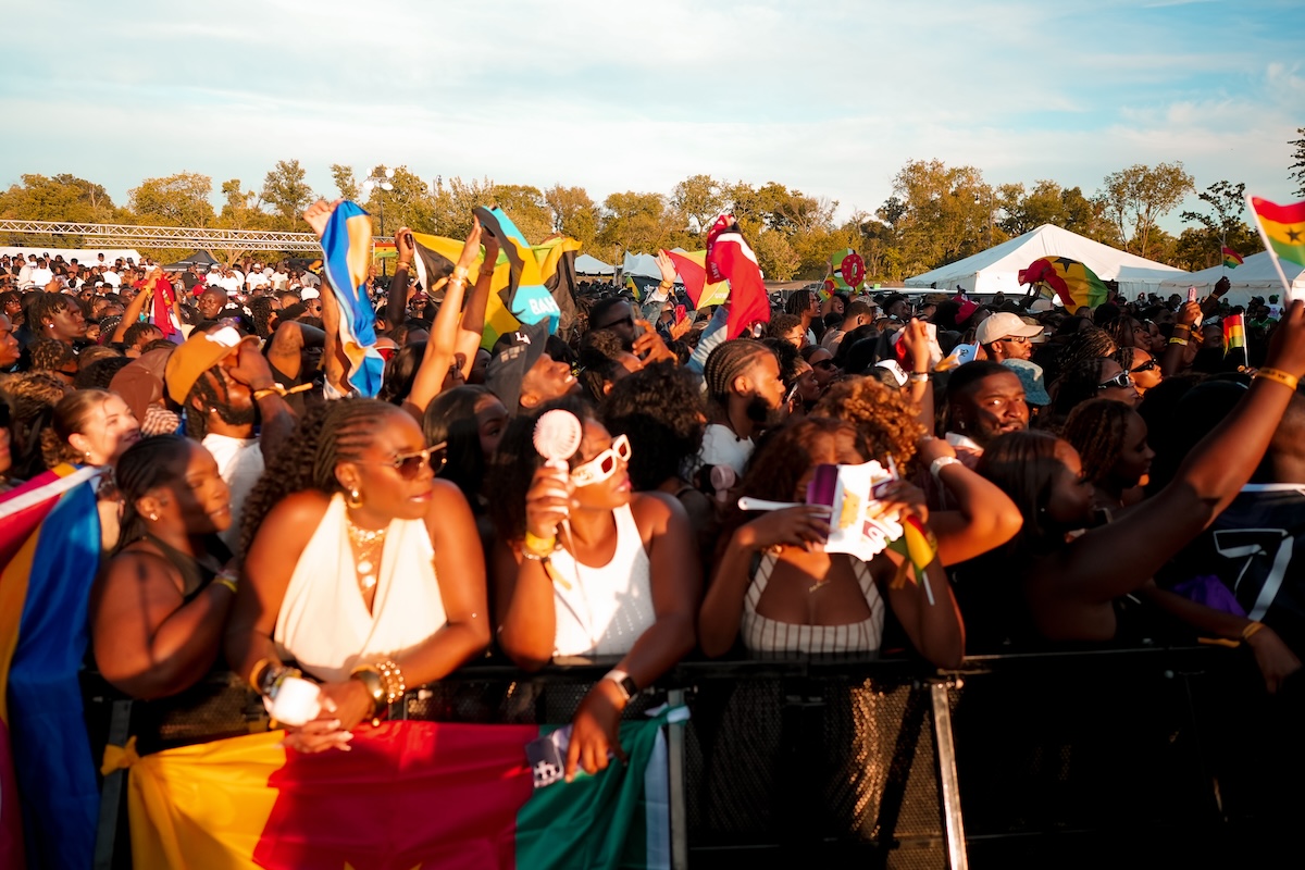 Black Caribbean concert crowd waving national flags vibrant festival atmosphere