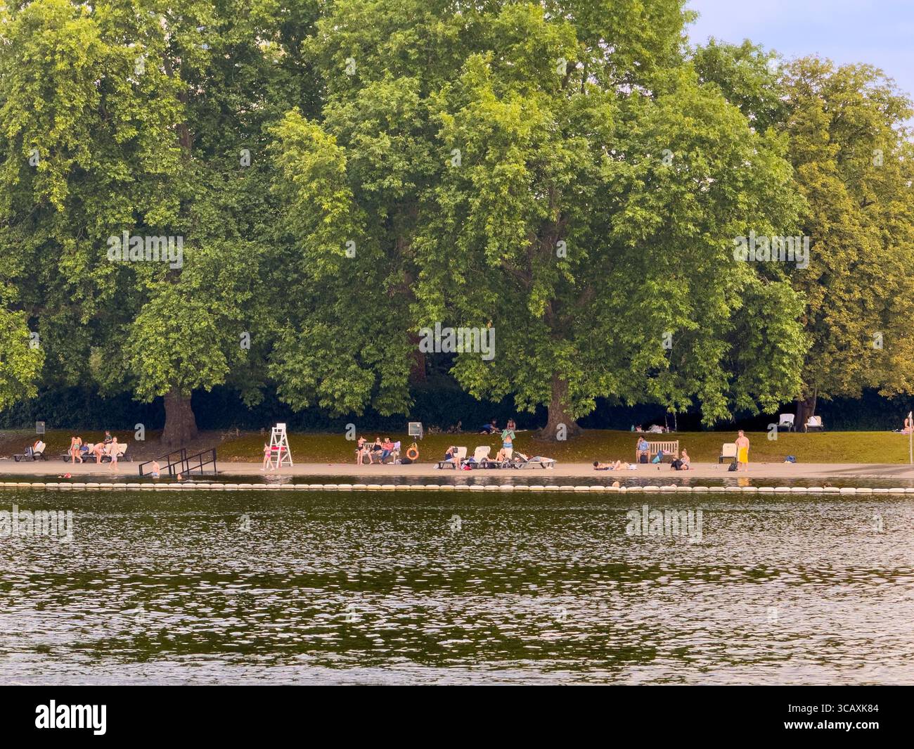 Hyde Park London Serpentine lake sunny day, people relaxing