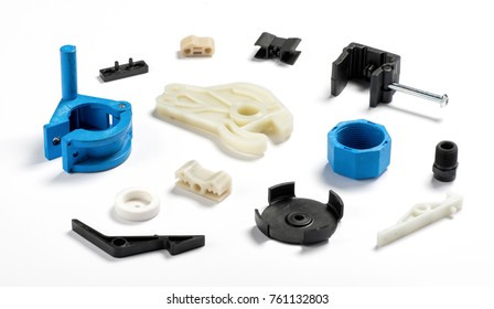 Collection of various detailed plastic injection molded parts like gears, medical casings, and automotive connectors, white background, studio shot
