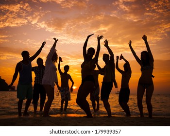 Silhouette of crowd dancing at sunset on the Ghana coast