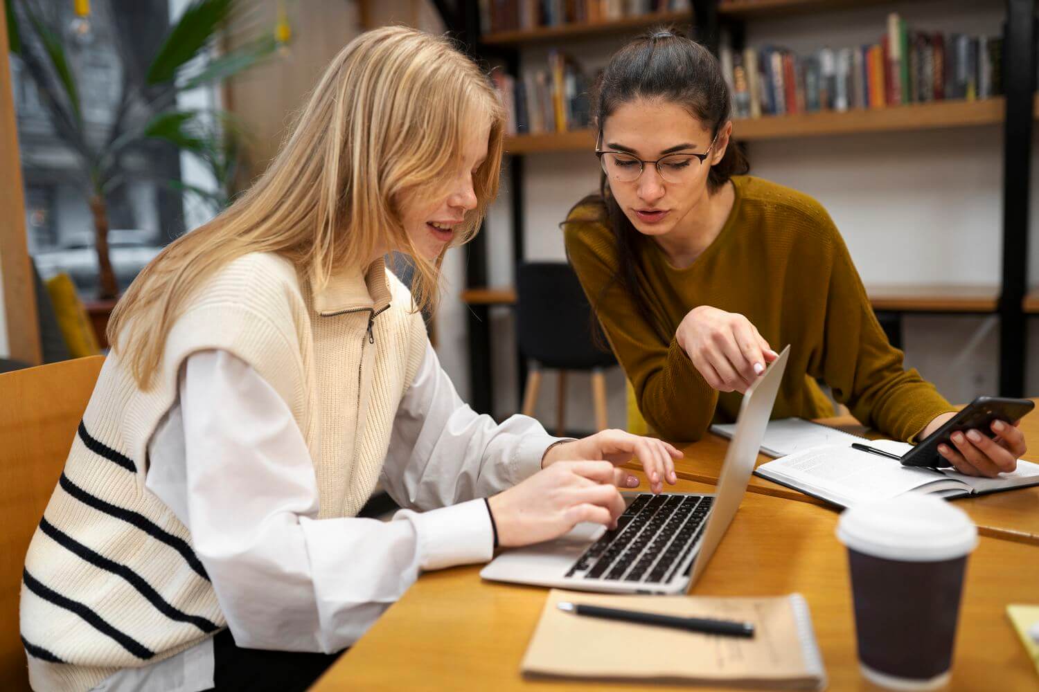 kind mentor helping a young student with a computer, warm lighting, office setting