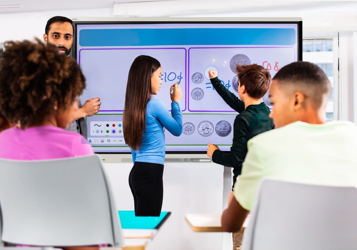 Teacher and student standing together at a large touchscreen smart board, smiling, interacting with digital content